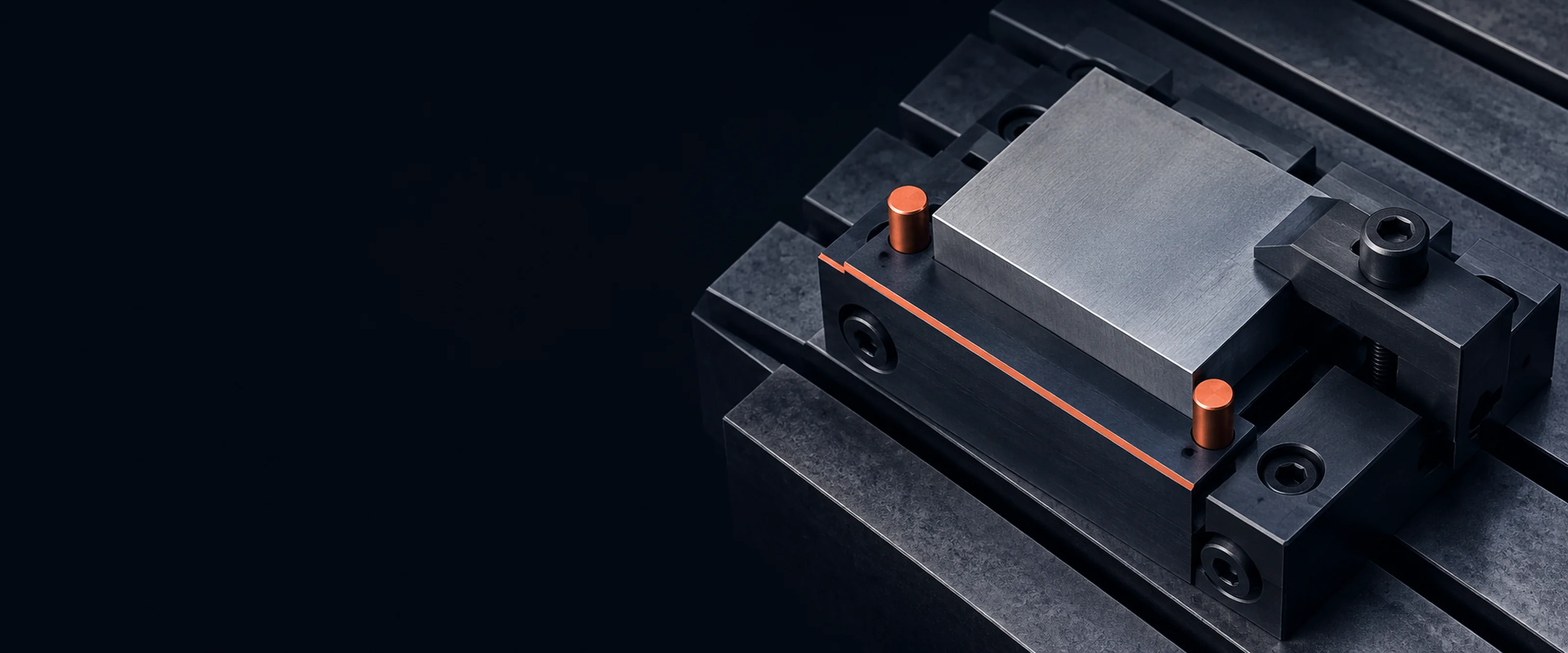 A machining fixture clamped on the slotted table of a milling machine, dark steel with two coral locating pins and a coral datum line along its edge.