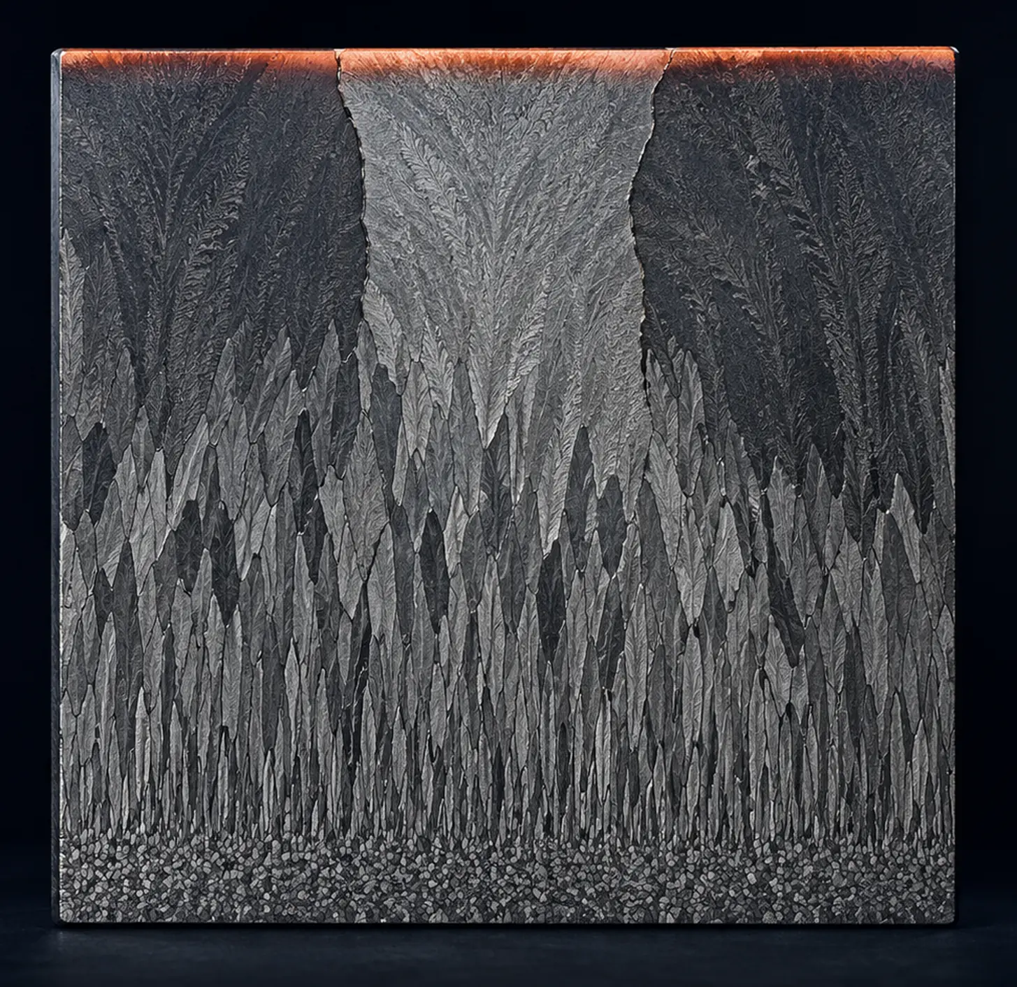 A polished, etched metal section: hundreds of thin grains at the bottom crowd each other out until three wide grains reach the top, where a band of hot metal still glows coral.